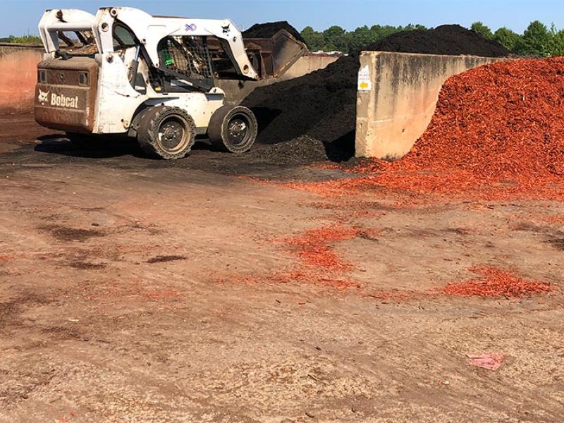 A bobcat scoopin mulch at Quality Landscape and Garden Center.